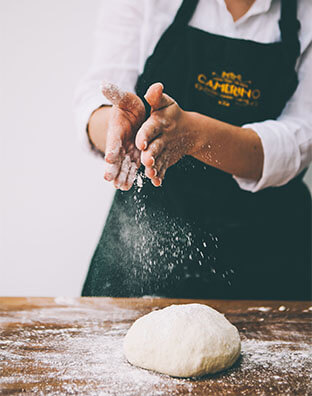 caryna camerino wears an apron as she flours some dough