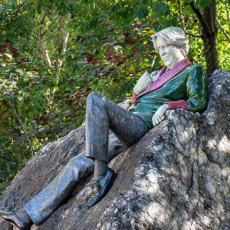 image of oscar wilde statue with green coat and blue trousers in merrion park