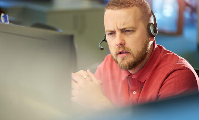 Man talking on phone headset in office for emergency services