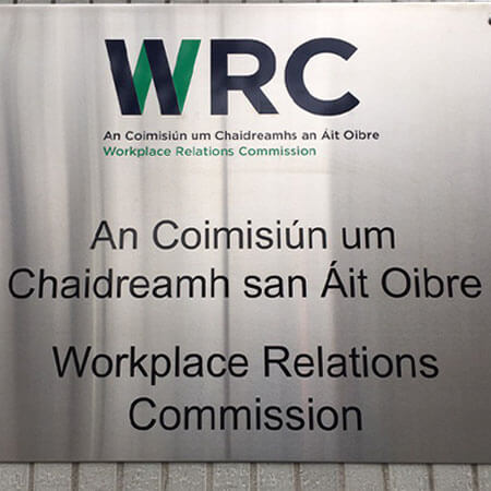 a silver sign marking the location of the workplace relations commission - the employee rights organisation
