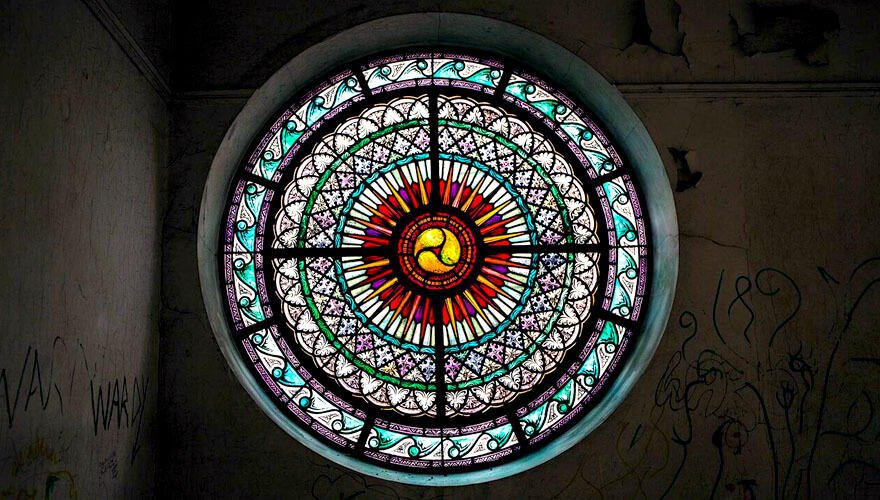 light shines through a circular stained glass window
