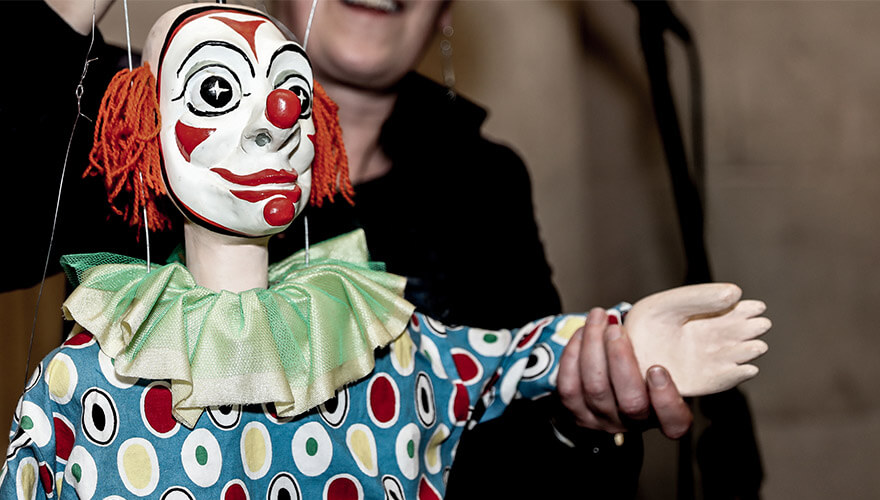 a red and white faced clown puppet from the five lamps arts festival