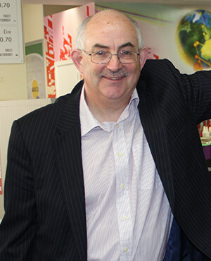 portrait of angus laverty in white short, black blazer and glasses
