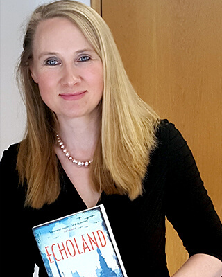 a photo of alison lyons, the director of the Dublin unesco City of Literature programme, holding a copy of echoland