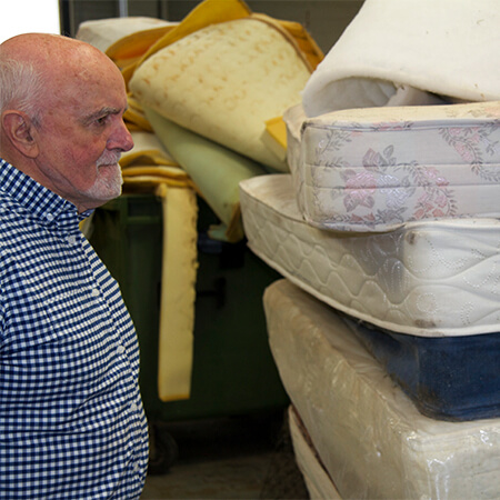 John Scally regards a stack of old mattresses