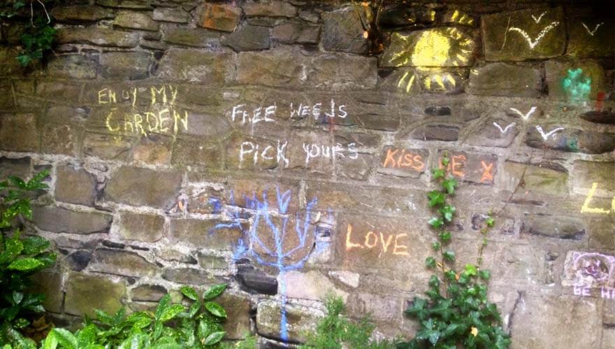yellow, orange, blue and white chalk drawings on a stone walls