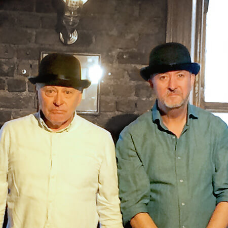 two actors/guides of the dublin literary pub crawl pose wearing black bowler hats