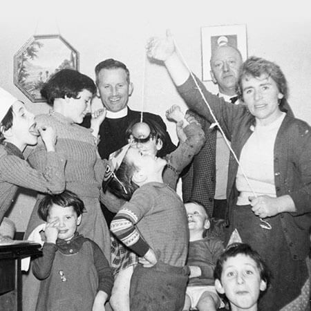 an old black and white photo of an irish family at christmas with a parish priest